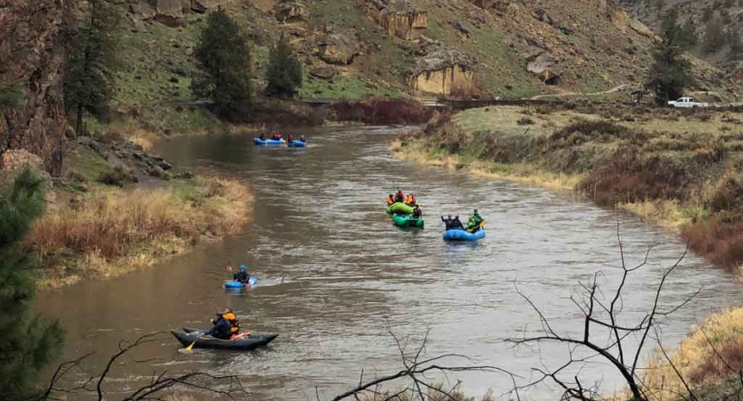 high school students paddle down a river on an outward bound course